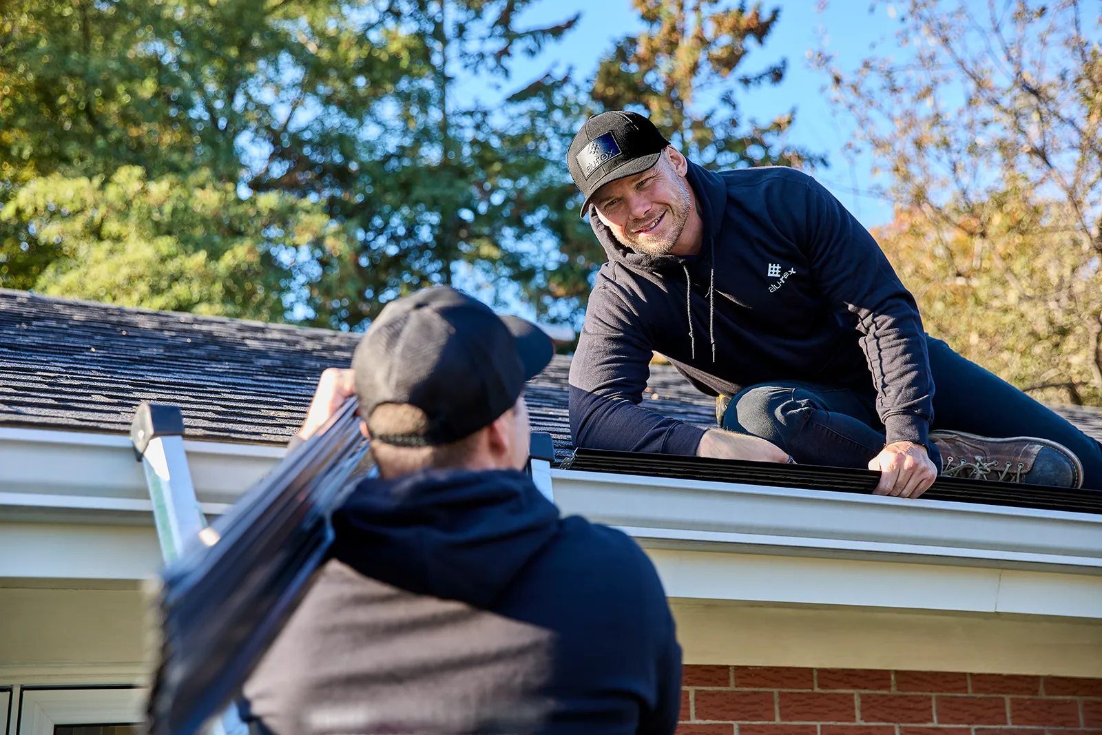 Crew working together at the roofline — Top Quality Construction LLC, Rice Lake WI